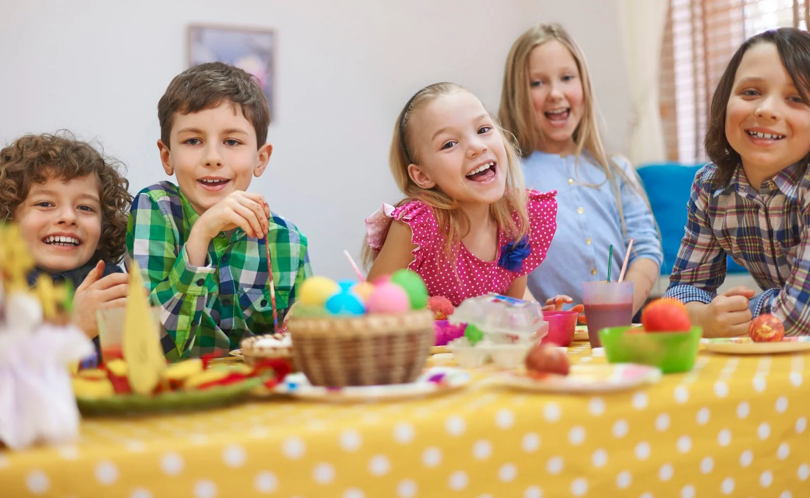 Happy children painting Easter eggs during a fun activity at childdaycaretracy