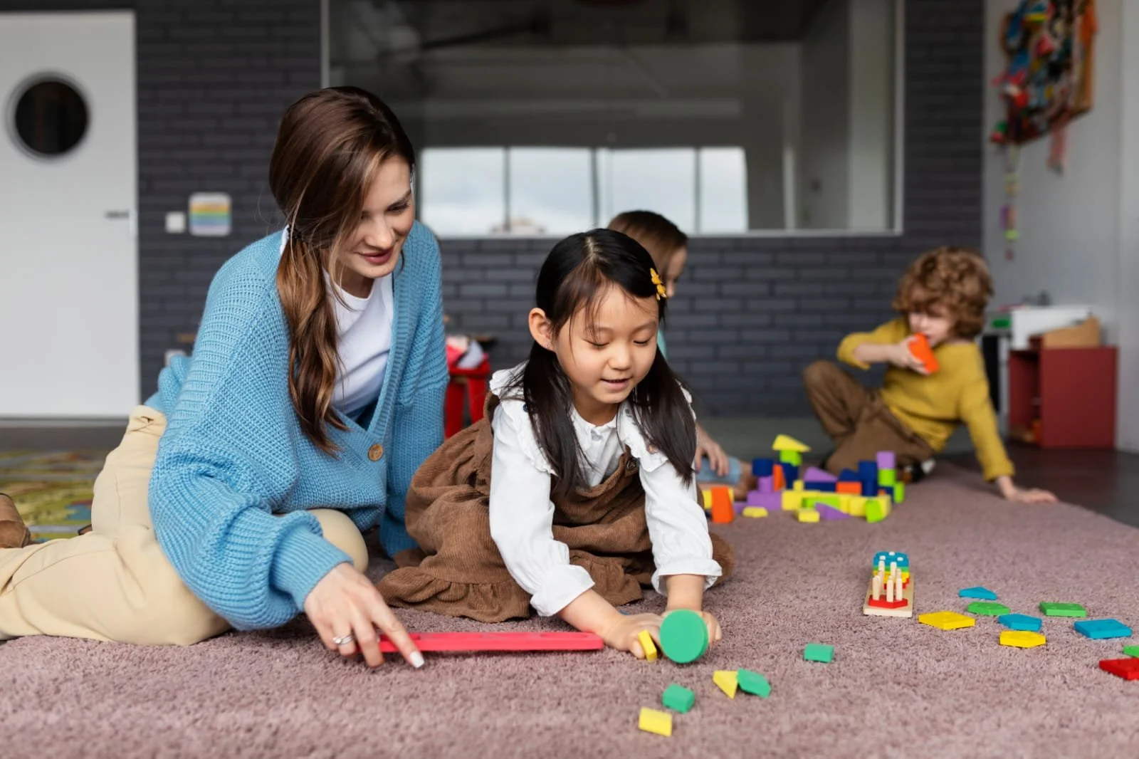 Teacher assisting children with educational shape-sorting toys at childdaycaretracy